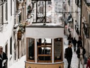brown tram along buildings