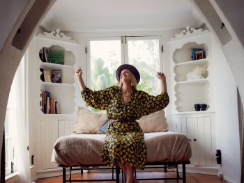 woman in brown and black floral dress sitting on brown wooden chair