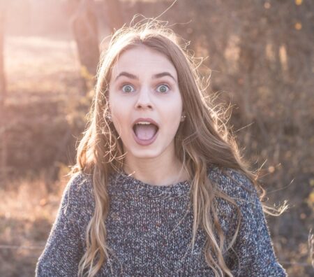 woman standing showing shocking face